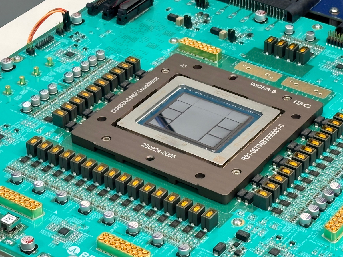 Close-up photograph of the Jalapeño package mounted on a teal green test board, a large square heat spreader frame around an exposed silicon die, surrounded by rows of gold capacitors and connectors, with a Broadcom logo visible at the bottom edge of the board.