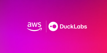 Official Amazon announcement graphic for the acquisition, showing the AWS logo and the DuckLabs logo side by side in white on a magenta and pink gradient background.