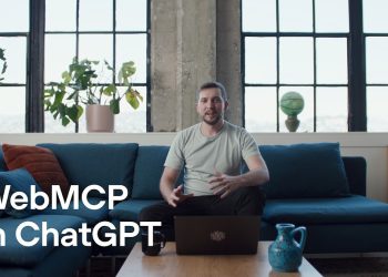 Title card from the OpenAI announcement video: a man sits on a blue sofa in a loft with tall windows and potted plants, a laptop open on the coffee table in front of him, with the words WebMCP in ChatGPT in large white type across the lower left.