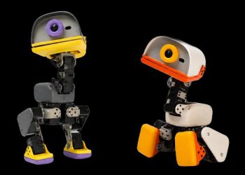 Four Microduck biped robots photographed side by side on a black background in the Sky, Graphite, Cream and Lavender colourways, each about 25 centimetres tall with a large duck-bill head housing a camera lens, exposed black servo-driven legs and coloured plastic feet.