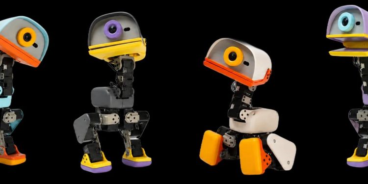 Four Microduck biped robots photographed side by side on a black background in the Sky, Graphite, Cream and Lavender colourways, each about 25 centimetres tall with a large duck-bill head housing a camera lens, exposed black servo-driven legs and coloured plastic feet.