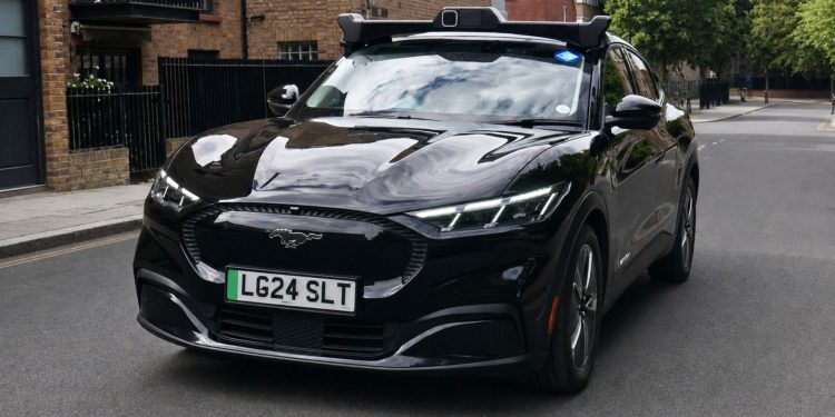 A Wayve autonomous Ford Mustang Mach-E in Uber livery on a London street, from the Wayve press release announcing that Transport for London granted private hire vehicle licences to its self-driving cars.