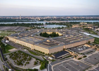 Aerial view of the Pentagon in Arlington, Virginia, at dusk, with the Potomac River and the Washington Monument in the background