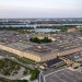 Aerial view of the Pentagon in Arlington, Virginia, at dusk, with the Potomac River and the Washington Monument in the background