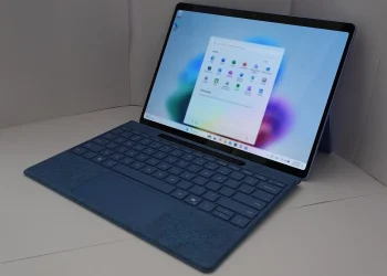 Microsoft Surface laptop with a blue keyboard cover showing the Windows 11 Start menu