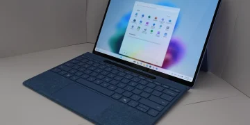 Microsoft Surface laptop with a blue keyboard cover showing the Windows 11 Start menu