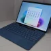 Microsoft Surface laptop with a blue keyboard cover showing the Windows 11 Start menu