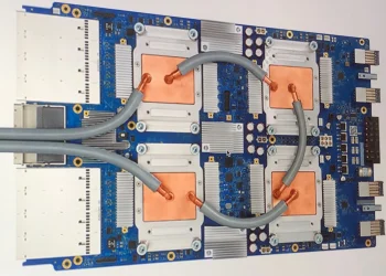 Photo of a Google Tensor Processing Unit 3.0 board with four chips, copper cold plates and grey coolant hoses
