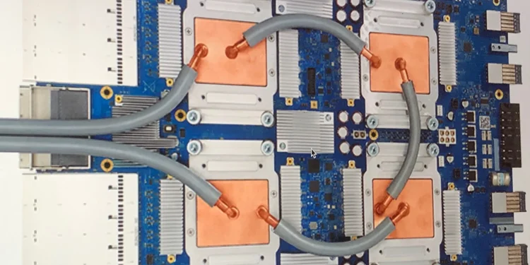 Photo of a Google Tensor Processing Unit 3.0 board with four chips, copper cold plates and grey coolant hoses
