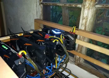 Five NVIDIA GTX 1070 graphics cards mounted in an open wooden frame, an Ethereum mining rig