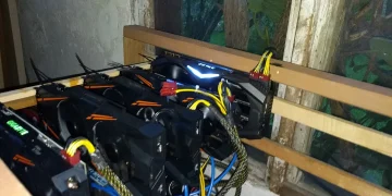 Five NVIDIA GTX 1070 graphics cards mounted in an open wooden frame, an Ethereum mining rig