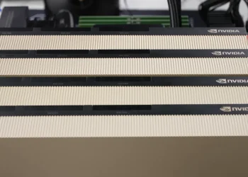 Four NVIDIA H100 GPU cards with gold heatsinks and NVLink connectors installed side by side in a test machine