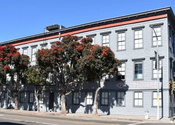 The Pioneer Building in the Mission District of San Francisco, a three-storey grey wooden building that houses the offices of OpenAI