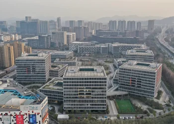 Aerial view of the Alibaba Center campus in Binjiang, Hangzhou, with blocky office buildings, green roof terraces and a football pitch
