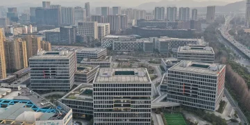 Aerial view of the Alibaba Center campus in Binjiang, Hangzhou, with blocky office buildings, green roof terraces and a football pitch