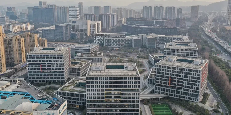 Aerial view of the Alibaba Center campus in Binjiang, Hangzhou, with blocky office buildings, green roof terraces and a football pitch
