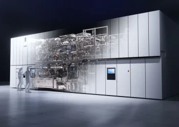 ASML render of a TWINSCAN EXE high-NA EUV lithography system in a cleanroom, with two technicians in white suits standing at its side