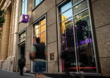 Street entrance of the Twitch headquarters building in San Francisco with the purple Twitch logo sign and a neon Twitch window sign