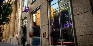 Street entrance of the Twitch headquarters building in San Francisco with the purple Twitch logo sign and a neon Twitch window sign