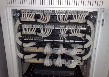 Network rack with D-Link Gigabit switches and Panduit patch panels connected by neatly bundled grey Ethernet patch cables