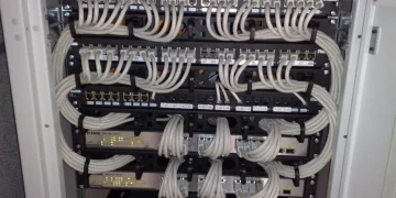 Network rack with D-Link Gigabit switches and Panduit patch panels connected by neatly bundled grey Ethernet patch cables