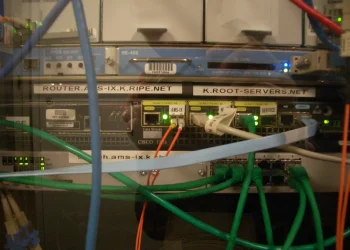 Rack of network equipment labelled K.ROOT-SERVERS.NET, the AMS-IX mirror of the K DNS root server, with Cisco router and patch cables